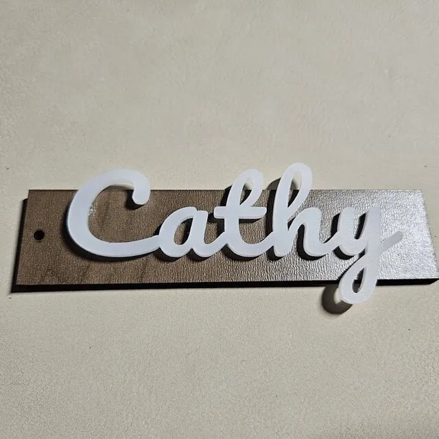Elegant stocking tag with Cathy text in white semi-translucent acrylic and walnut plywood
